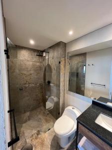 a bathroom with a toilet and a glass shower at R2 - Moderno Loft en la historica Candelaria in Bogotá