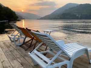 a group of chairs sitting on a dock near the water at Villa Pliva Lake Jajce in Jajce