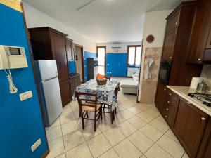 eine Küche mit einem Tisch und eine Küche mit blauen Wänden in der Unterkunft ORIO Bergamo 24h AIRPORT BGY- a few step - VICINO ALL'AEROPORTO in Orio al Serio + 14 Fotos