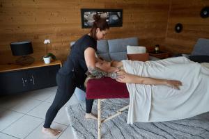 uma mulher sentada numa cama com uma mulher deitada em Gîte clair, spacieux et cosy avec vue sur le massif de la Chartreuse em Sainte-Hélène-du-Lac