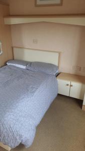 a bedroom with a bed and two night stands at Shell’s Caravan in Lincolnshire