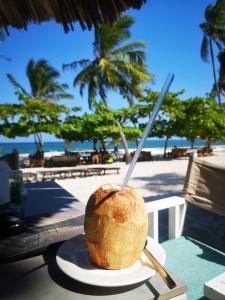 a coconut on a plate on a table near the beach at Jameela House, 3 mins to Diani Beach, Spa, Laundry, Transport & Catering Available in Ukunda