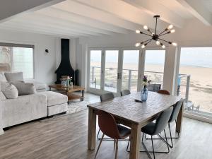a living room with a table and chairs and a couch at Luxury Beachfront Condo - Endless Views - Surf 1 in Sunset Beach