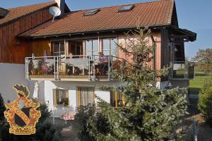 a house with people sitting on a balcony at Bodenseegästehaus in Uhldingen-Mühlhofen