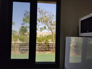 a window with a view of a tree and a fence at רוגע במדבר מרחב עם in Merhav Am