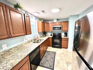 a kitchen with wooden cabinets and a stainless steel refrigerator at The Absolute Best Home Away From Home Pet Friendly!!! in Wilmington