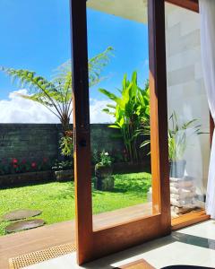 una puerta abierta a un jardín con plantas en BUYAN LODGE lake view villa, en Bedugul