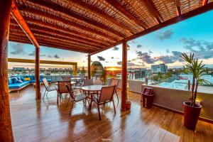 a balcony with tables and chairs and a view of the water at Hotel Aracaju Suites in Aracaju