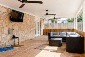 sala de estar con sofá y TV en una pared de piedra. en Great home, great location at a great price!, en San Antonio