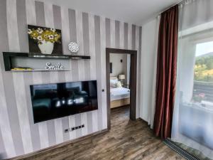 a living room with a flat screen tv on a striped wall at Silver Mountain G1 39 Perfect For You in Poiana Brasov