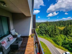 a balcony with a couch and a view of a road at Silver Mountain G1 39 Perfect For You in Poiana Brasov