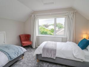 a bedroom with a bed and a window and a chair at Lleifior in Dolgellau