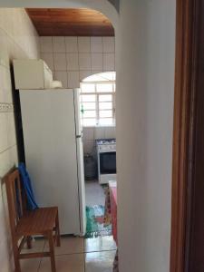 a kitchen with a white refrigerator and a chair at Casa Bela in Bonito