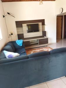 a living room with a blue couch and a tv at Casa Bela in Bonito