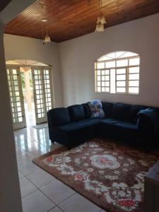 a living room with a blue couch and a rug at Casa Bela in Bonito