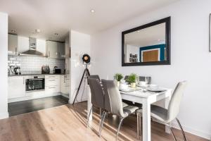 a kitchen and dining room with a white table and chairs at Host & Stay - The Baltic Penthouse with Balcony in Liverpool