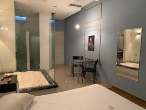 1 dormitorio con cama, mesa y bañera en Motel Vivre (Adult Only), en São Paulo