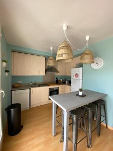 a kitchen with a table and chairs in it at Superbe appartement rénové, résidence avec piscine in Roses