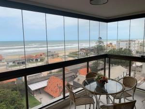 アホイオ・ド・シウヴァにあるApartamento Beira Marのテーブルと椅子が備わり、海の景色を望めます。