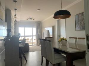 a kitchen and living room with a table and chairs at Apartamento Beira Mar in Arroio do Silva