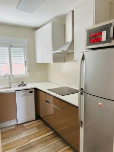 uma cozinha com armários brancos e um frigorífico em Fantástico piso NUEVO en el centro de Benidorm em Benidorm