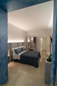 1 dormitorio con 1 cama grande con almohadas azules en Le margherite B&B, en Mesagne