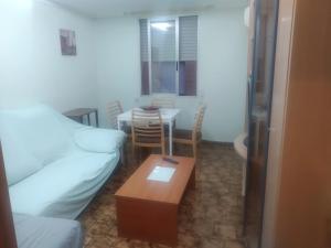 ein Wohnzimmer mit Couch und Tisch in der Unterkunft Piso entero cerca de Valencia y sus playas. in Albalat dels Sorells
