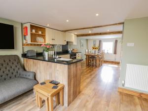 a kitchen and living room with a couch and a table at Pen Y Bont Ucha in Llandudno Junction