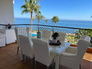 a balcony with a table and chairs and the ocean at MI CAPRICHO, Beach Front Apartment P14 3ºB in Mijas Costa