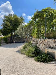 a stone fence and a stone wall and trees at Trullo Matilde in Martina Franca