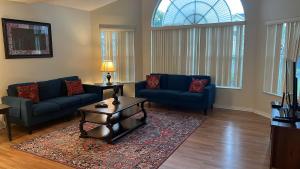 基西米的住宿－Orlando House Disney Area，客厅配有2张蓝色的沙发和1张桌子