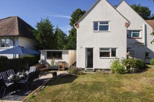 a house with a yard with chairs and an umbrella at Penylan in Seaton