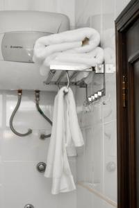 MJ Grand Hotel في إيست ليغون: حمام به مناشف بيضاء على رف للمناشف