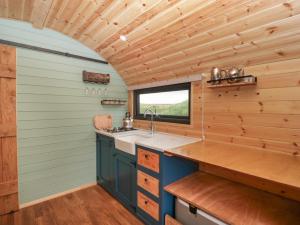 eine Küche mit Holzwänden, einem Fenster und einem Waschbecken in der Unterkunft Lime Kiln in Blagdon