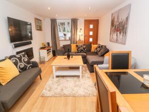 a living room with a couch and a table at Fair Mead Cottage in Saltash