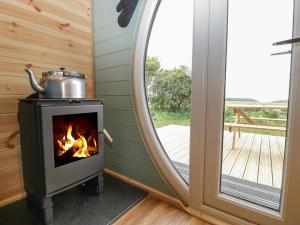 a wood stove in a room next to a mirror at Dew Pond in Blagdon