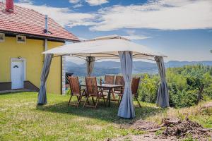 a table and chairs under a large umbrella at Eko Pony Ranch Ogrizek in Podčetrtek