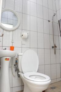 La salle de bains est pourvue de toilettes blanches et d'un miroir. dans l'établissement ENJOY n RELAX, à Douala