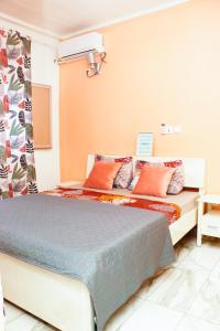 um quarto com uma cama com almofadas laranja e azul em ENJOY n RELAX em Douala