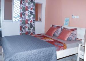 um quarto com uma cama com almofadas vermelhas em ENJOY n RELAX em Douala