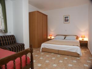 a small bedroom with a bed and a couch at Apartments by the sea Crikvenica - 2354 in Crikvenica