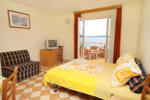 a bedroom with a bed and a television and a balcony at Apartments by the sea Crikvenica - 2354 in Crikvenica
