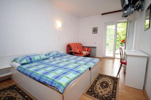 a bedroom with a bed and a chair at Apartment Selce 2379a in Selce