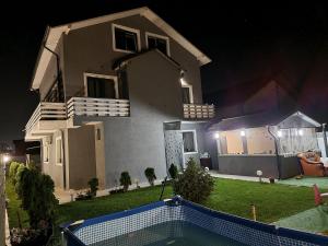 a house with a swimming pool in the yard at night at Casa Izabela in Năvodari