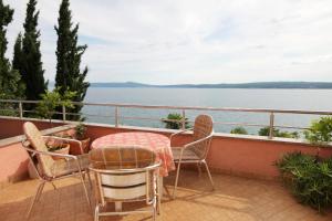 a balcony with a table and chairs and a view of the water at Apartments by the sea Crikvenica - 2354 in Crikvenica