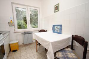 a kitchen with a table and two chairs and a window at Apartment Selce 2379a in Selce