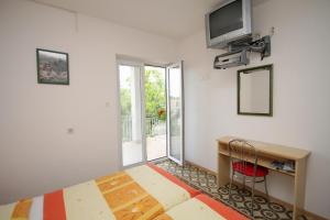 a room with a desk and a television on a wall at Apartment Selce 2379b in Selce