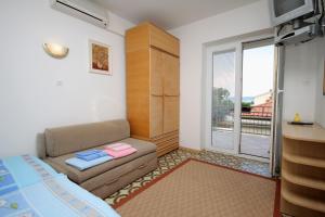 a bedroom with a couch and a bed and a window at Apartment Selce 2379b in Selce