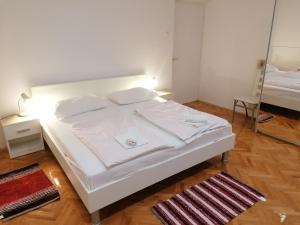 białe łóżko w pokoju z lustrem w obiekcie Apartment Selce 2381d w mieście Selce