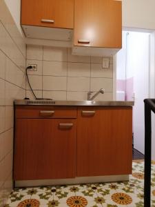 a kitchen with wooden cabinets and a sink at Apartment Selce 2381d in Selce